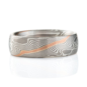 Silvery mokume gane ring made in twisting pattern, with one streak of red gold running through.