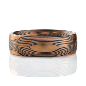 Mokume gane ring patterned in Arn Krebs "Flow", resembles running water from an overhead view, with oval shaped pieces of solid gold placed intermittently. 