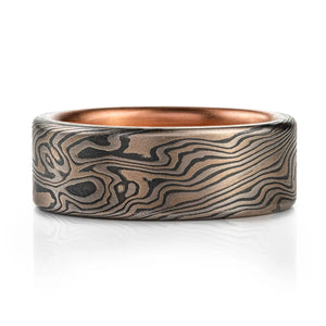 dark mokume gane ring in twist pattern with a dark oxidized finish and a red gold liner