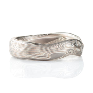 Flat profile band made in mokume twist style pattern, with added surface carving and etched finish for a bumpy texture.